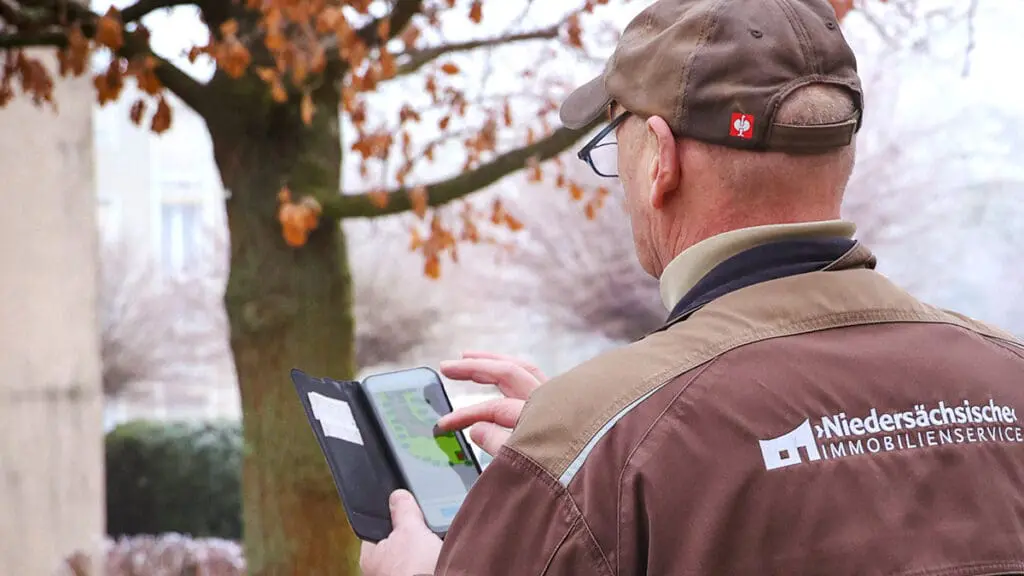 Bild: WIEDERAUFBAU Ein Kollege der Niedersächsischen Immobilienservice GmbH beim Erfassen des Zustands eines Baumes im Programm Immospector Tree.