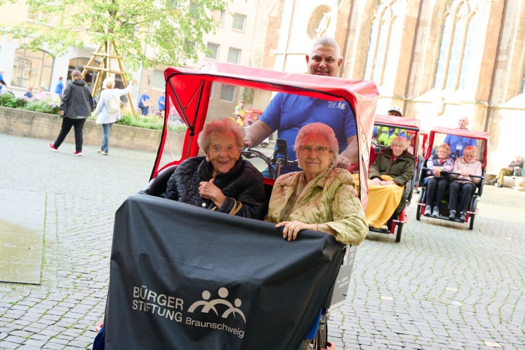 Bild: © Bürgerstiftung Braunschweig Ein Rikschafahrer und zwei Seniorinnen als seine Fahrgäste.
