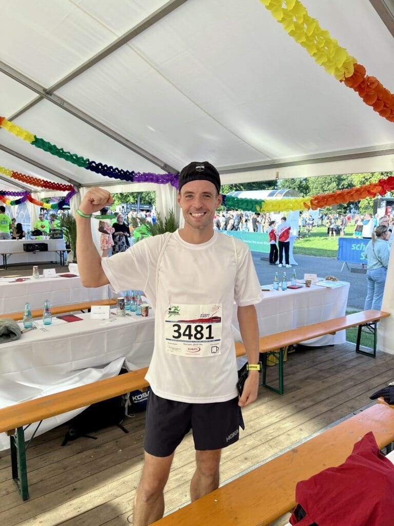 Bild: © WIEDERAUFBAU Daniel Müller steht jubelnd in einem Zelt.