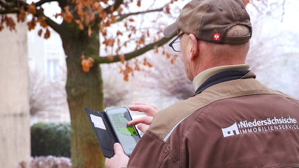 Bild: WIEDERAUFBAU Ein Kollege der Niedersächsischen Immobilienservice GmbH beim Erfassen des Zustands eines Baumes im Programm Immospector Tree.