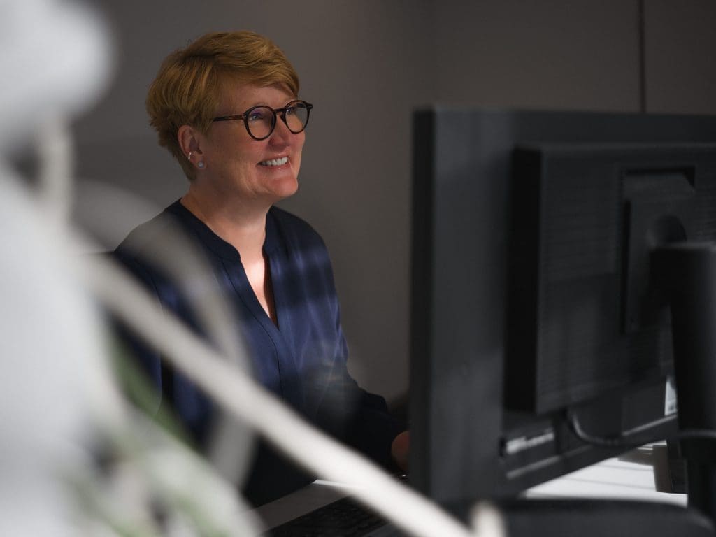 Bild: © Tom Tautz Frau sitzt am Schreibtisch vor ihrem PC.