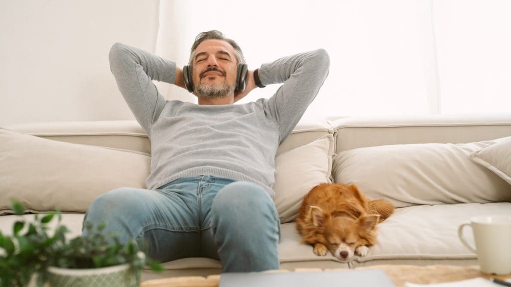 Bild: © iStockphoto.com/zGel , Mann mit Hund auf Sofa