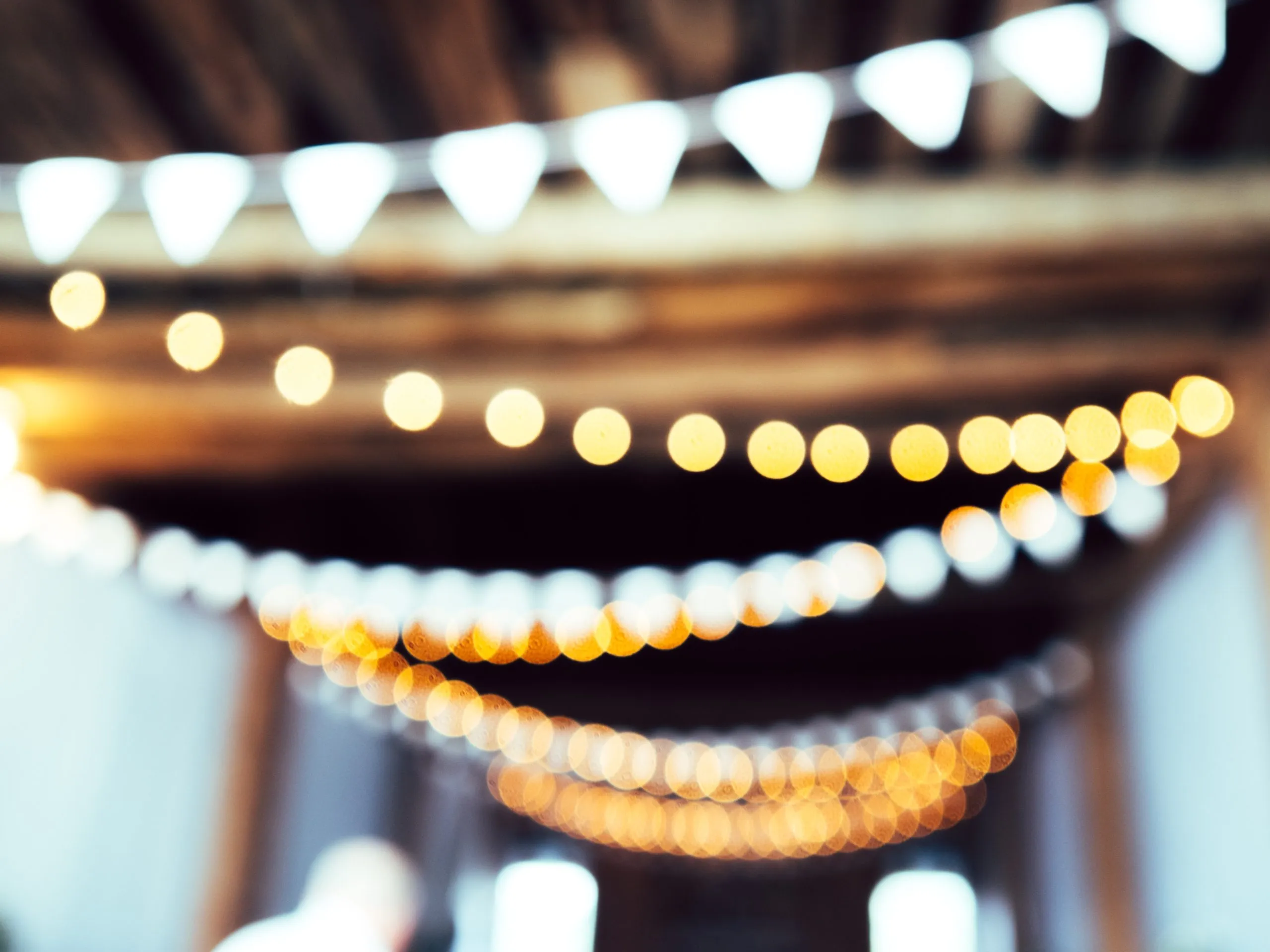 Bild: © Unsplash Ein unscharfes Bild von leuchtenden Lichterketten an der Decke.