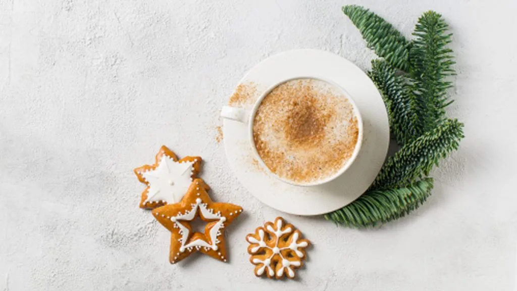 © iStockphoto.com/Dannko Eine Tasse mit Heißgetränk, Lebkuchen und einem Tannenzweig.