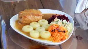 Bild: © WIEDERAUFBAU Ein Teller mit einer Roulade, Klößen, Soße und Salat.