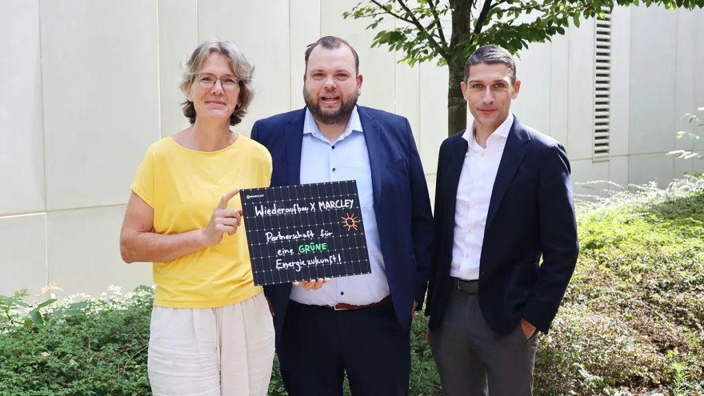 Bild: © WIEDERAUFBAU Drei Personen stehen zusammen und halten ein kleines Solarpaneel in den Händen.