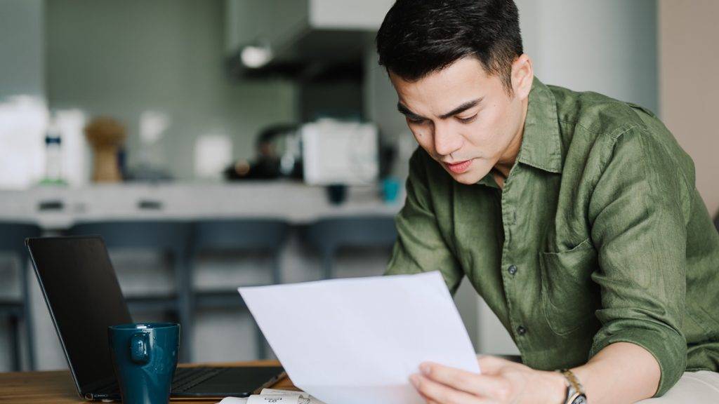 Bild: © iStockphotodotcom-ChongKeeSiong Ein Mann hält ein Blatt Papier und liest.