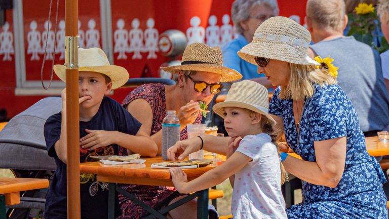 Bild: © bs_live Eine Familie an einer Bierzeltgarnitur während der Mieterveranstaltung "Unser Sommer 2022".