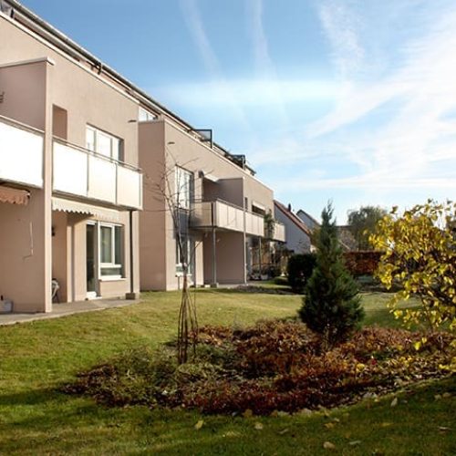 Bild: © WIEDERAUFBAU Blick von der Grünfläche auf das mehrstöckige Betreute Wohnen mit Terrassen und Balkonen in Cremlingen.