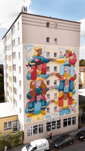 Bild: © Verena Meier Achtstöckiges Wohngebäude mit Fassadenbemalung.