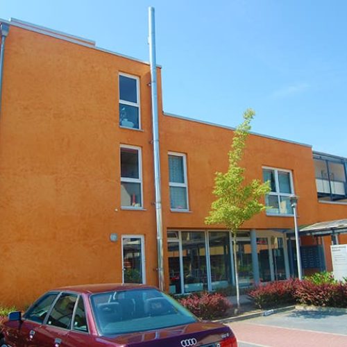 Bild: © WIEDERAUFBAU Eingangsbereich des dreistöckigen Betreuten Wohnens mit angeschlossenem Parkplatz in Volkmarode.