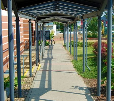 Bild: © WIEDERAUFBAU Überdachter Fußweg entlang des mehrstöckigen Betreuten Wohnens Volkmarode.