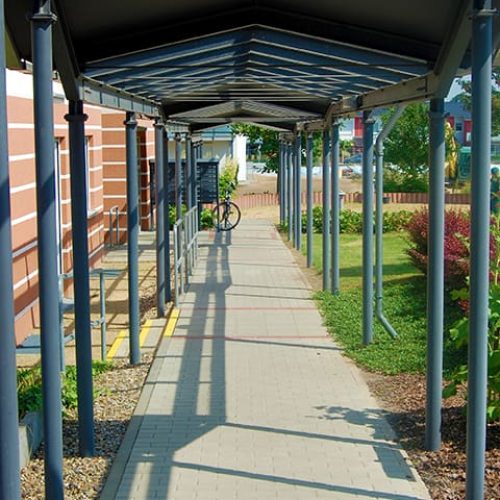 Bild: © WIEDERAUFBAU Überdachter Fußweg entlang des mehrstöckigen Betreuten Wohnens Volkmarode.