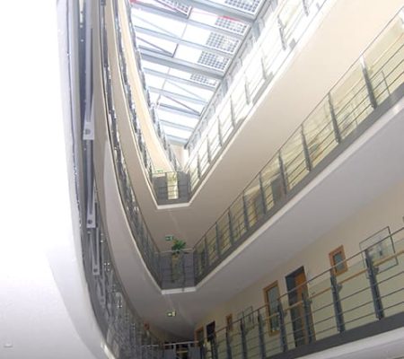 Bild: © WIEDERAUFBAU Ansicht auf die schmal zulaufenden Gänge der oberen Stockwerke im Betreuten Wohnen Braunschweig-Weststadt.