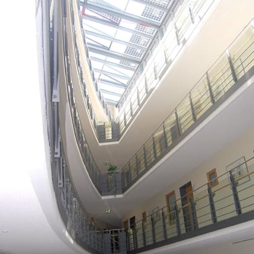 Bild: © WIEDERAUFBAU Ansicht auf die schmal zulaufenden Gänge der oberen Stockwerke im Betreuten Wohnen Braunschweig-Weststadt.