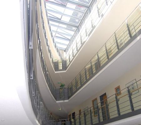 Bild: © WIEDERAUFBAU Ansicht auf die schmal zulaufenden Gänge der oberen Stockwerke im Betreuten Wohnen Braunschweig-Weststadt.