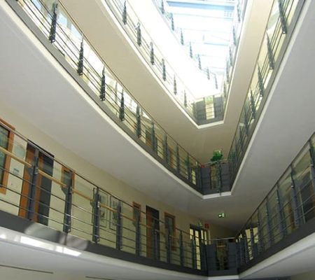 Bild: © WIEDERAUFBAU Innenansicht des Betreuten Wohnen Braunschweig-Weststadt mit schmal zulaufenden Wänden und Blick auf die oberen Stockwerke.