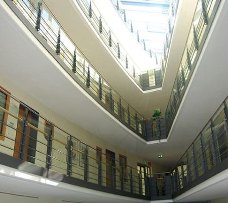 Bild: © WIEDERAUFBAU Innenansicht des Betreuten Wohnen Braunschweig-Weststadt mit schmal zulaufenden Wänden und Blick auf die oberen Stockwerke.