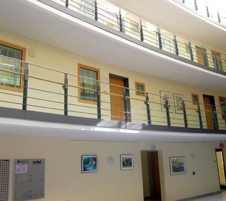 Bild: © WIEDERAUFBAU Blick vom offenen Foyer nach oben zu den Wohnungstüren des 1., 2. und dritten Stockwerks des Betreuten Wohnen Braunschweig-Weststadt.