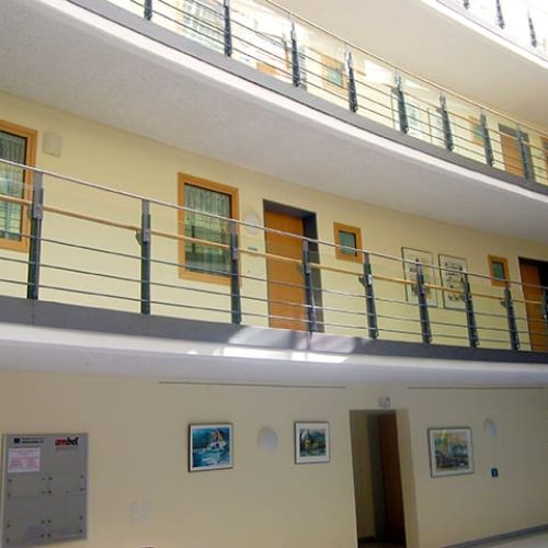 Bild: © WIEDERAUFBAU Blick vom offenen Foyer nach oben zu den Wohnungstüren des 1., 2. und dritten Stockwerks des Betreuten Wohnen Braunschweig-Weststadt.