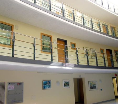 Bild: © WIEDERAUFBAU Blick vom offenen Foyer nach oben zu den Wohnungstüren des 1., 2. und dritten Stockwerks des Betreuten Wohnen Braunschweig-Weststadt.