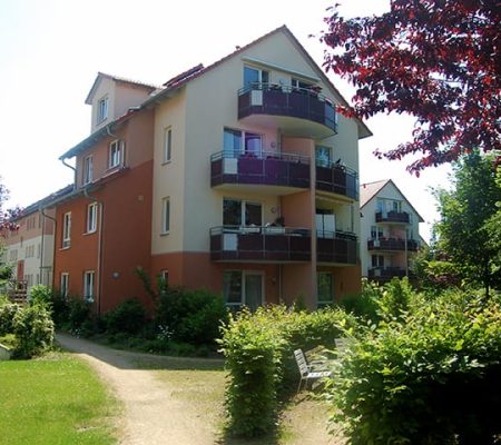 Bild: © WIEDERAUFBAU Blick von der Grünanlage auf das mehrstöckige Betreute Wohnen mit Balkonen in Querum.
