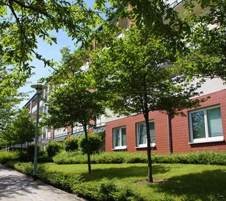 Bild: © WEDERAUFBAU Vor dem mehrstöckiger Wohnkomplex des Betreuten Wohnens Broitzem stehen Bäume.