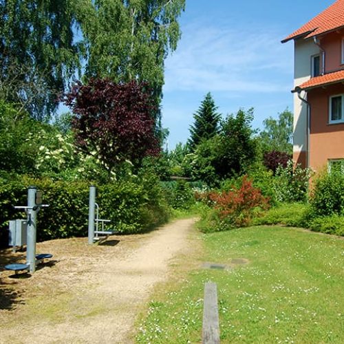 Bild: © WIEDERAUFBAU Bewegungsparcours an einer Wiese vor dem mehrstöckigen Betreuten Wohnen Querum.