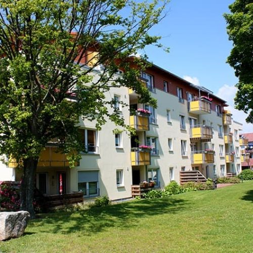Bild: © WIEDERAUFBAU Blick auf das mehrstöckige Wohngebäude mit Rasenfläche in der Liegnitzer Straße in Goslar.