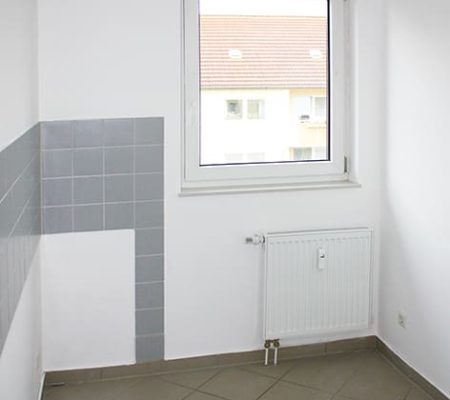 Bild: © WIEDERAUFBAU Beispiel einer Küche mit Fenster und grauen Fliesenspiegel im Betreuten Wohnen Goslar.