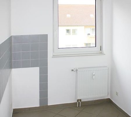Bild: © WIEDERAUFBAU Beispiel einer Küche mit Fenster und grauen Fliesenspiegel im Betreuten Wohnen Goslar.