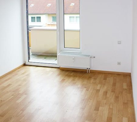 Bild: © WIEDERAUFBAU Beispiel eines Wohnzimmers mit Balkon im Betreuten Wohnen Goslar.