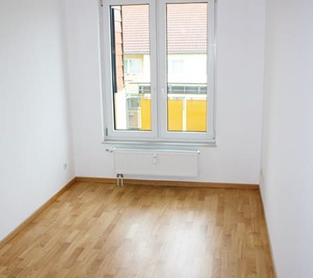 Bild: © WIEDERAUFBAU Beispiel eines Schlafzimmers mit Fenster und hellbraunen Bodenbelag im Betreuten Wohnen Goslar.