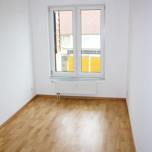 Bild: © WIEDERAUFBAU Beispiel eines Schlafzimmers mit Fenster und hellbraunen Bodenbelag im Betreuten Wohnen Goslar.