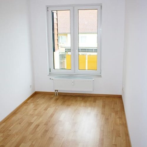 Bild: © WIEDERAUFBAU Beispiel eines Schlafzimmers mit Fenster und hellbraunen Bodenbelag im Betreuten Wohnen Goslar.