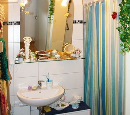 Bild: © WIEDERAUFBAU Ein Badezimmer mit weißen Fließen und bodengleicher Dusche im Betreuten Wohnen Querum.