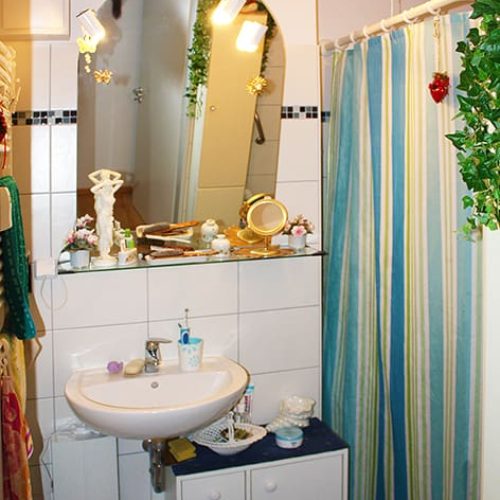 Bild: © WIEDERAUFBAU Ein Badezimmer mit weißen Fließen und bodengleicher Dusche im Betreuten Wohnen Querum.