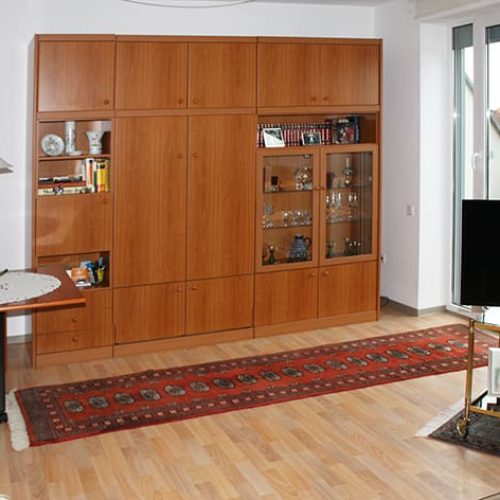 Bild: © WEDERAUFBAU Ein Wohnzimmer im Betreuten Wohnen Juliusstraße mit bodentiefem Fenster und hellem Bodenbelag.