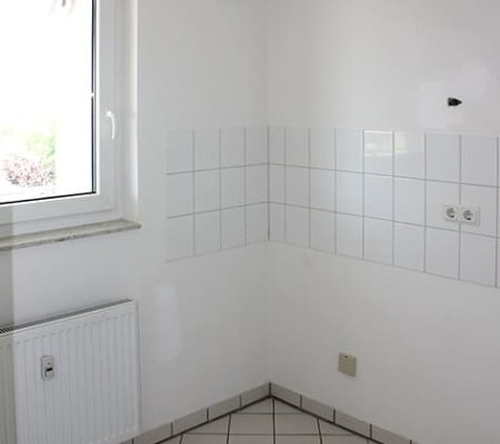 Bild: © WEDERAUFBAU Die Küchenzeile mit weißem Fliesenspiegel und weißen Bodenfliesen in Broitzem.