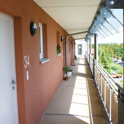 Bild: © WEDERAUFBAU Ein Laubengang mit Wohnungstüren des Betreuten Wohnen in Broitzem.